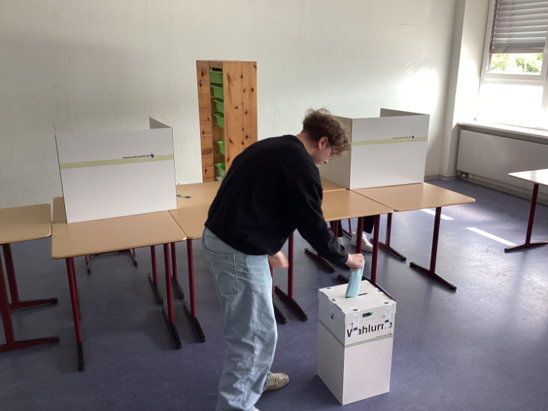 Die Stimmabgabe erfolgt in eine mit Kunststoffbändern und Klebesiegeln versiegelte Wahlurne. 